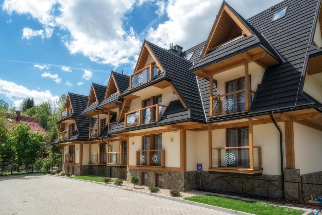 een rij huizen met zwarte daken bij Apartamenty Pod Gubałówką in Zakopane