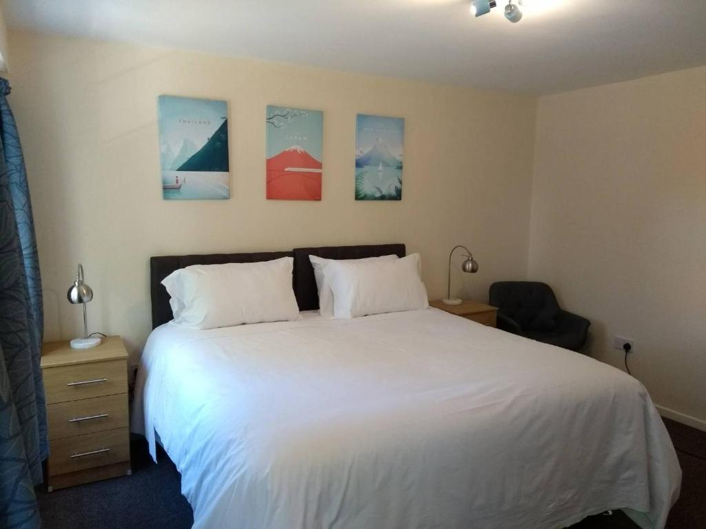 una camera da letto con un grande letto bianco con due cuscini di The Tiger - formerly Cassia Rooms a Worksop