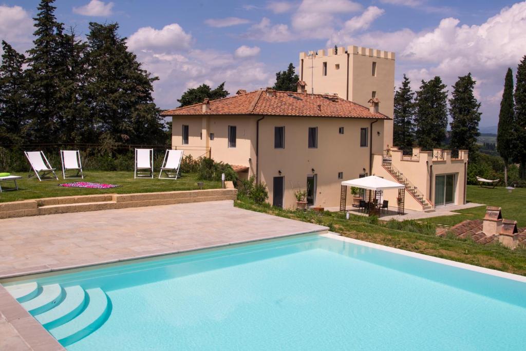 une villa avec une piscine en face d'un bâtiment dans l'établissement Villa la torre, à Montespertoli