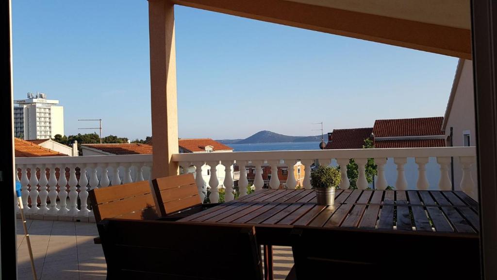 a table on a balcony with a view of the ocean at Apartmani Mira in Vodice