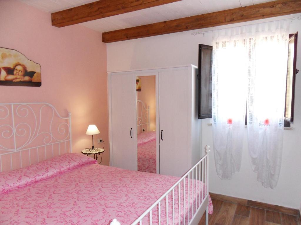 sypialnia z różowym łóżkiem i oknem w obiekcie Resort Paradise Marina di Camerota w mieście Marina di Camerota