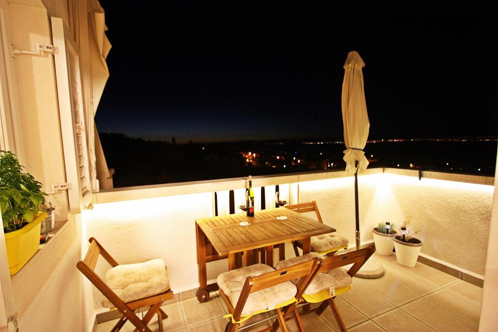 a table and chairs on a balcony at night at The View in Supetar