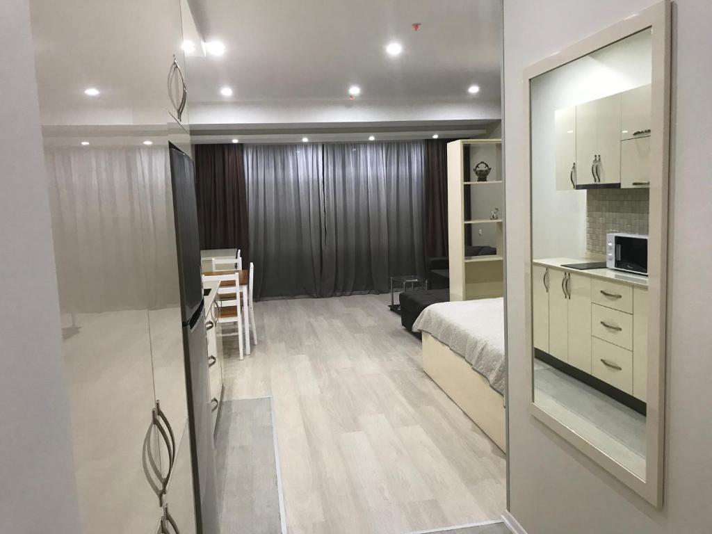 a bedroom with a bed and a kitchen and a table at Batumi Porta Tower 1611 in Batumi