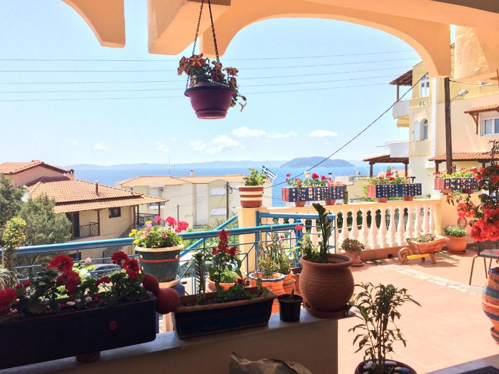 a balcony with potted plants in pots on a balcony at Alexia House in Neos Marmaras