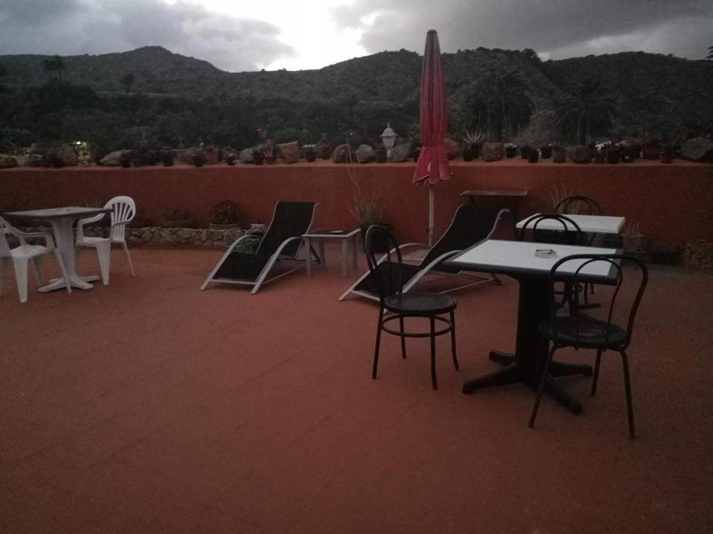 a patio with chairs and tables and an umbrella at Residencia Los Conejos - Bike & Motorbike in Las Palmas de Gran Canaria