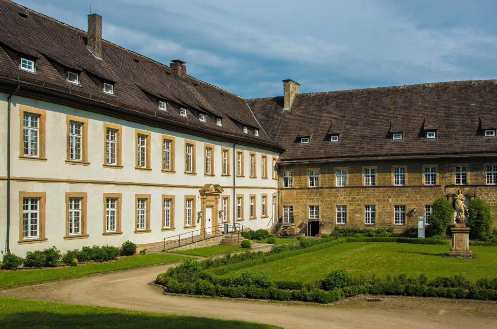 einen Innenhof eines großen Gebäudes mit Garten in der Unterkunft Hotel Schloß Gehrden in Gehrden