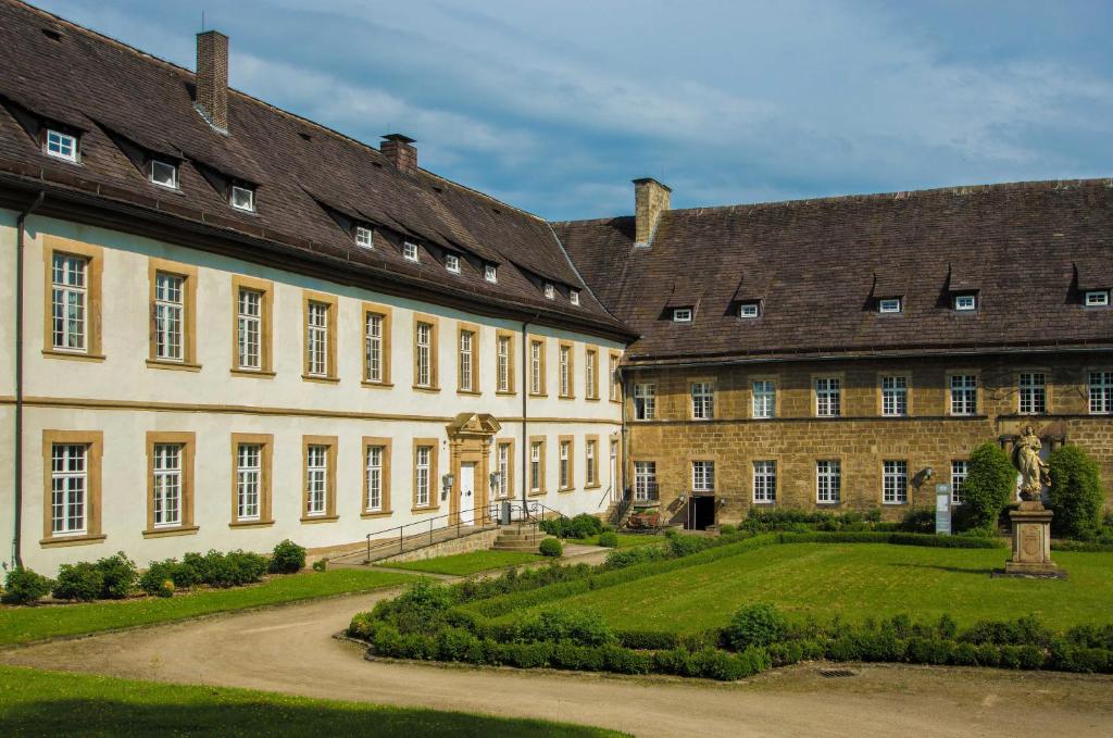 une cour d'un grand bâtiment avec un jardin dans l'établissement Hotel Schloß Gehrden, à Gehrden