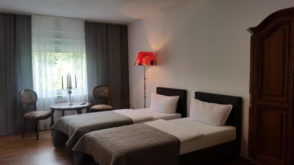 um quarto de hotel com duas camas e um candeeiro vermelho em Monte Christo em Miastko