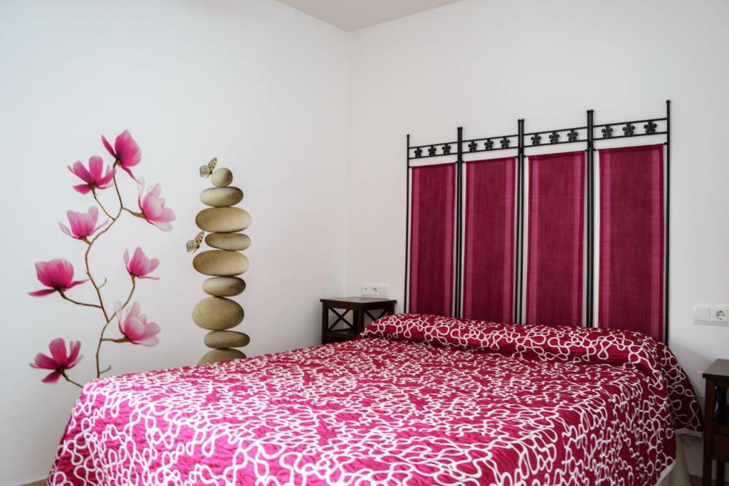 um quarto com uma cama com uma colcha vermelha em "Ventana del Guadalquivir " em Baeza