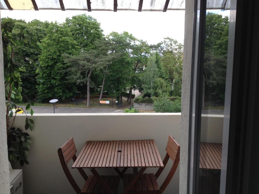 a table and chairs on a balcony with a window at Appartement Meurisse 7 in Metz