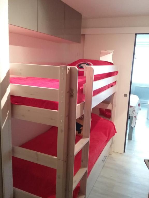 サン・ラリー・スランにあるBEL AURE 3のベッドルーム1室(赤いシーツを使用した二段ベッド2組付)