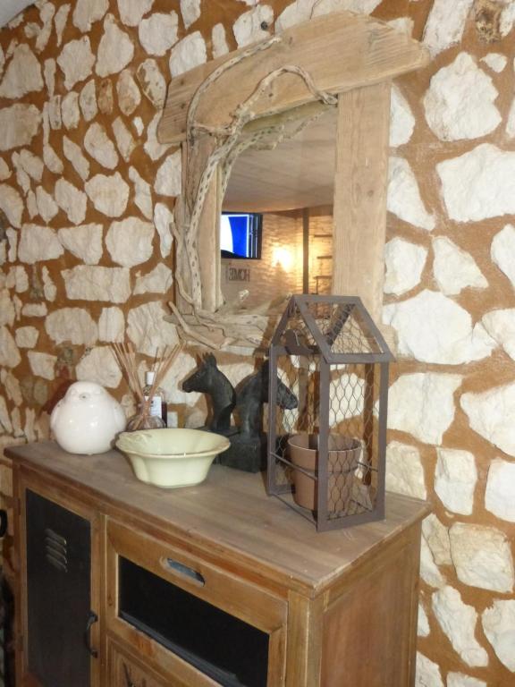 a room with a stone wall with a counter with a mirror at Chez Isa in Yport