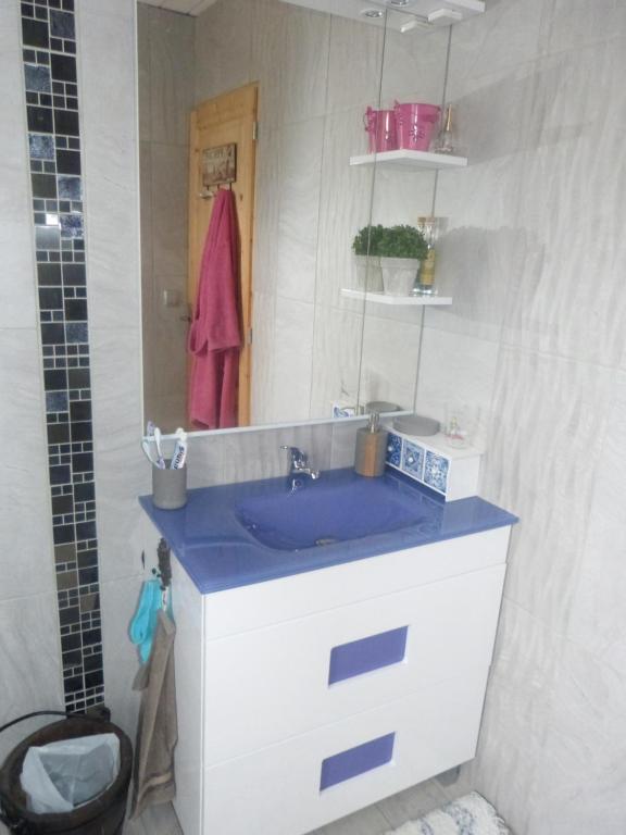 a bathroom with a blue sink and a mirror at Chez Isa in Yport