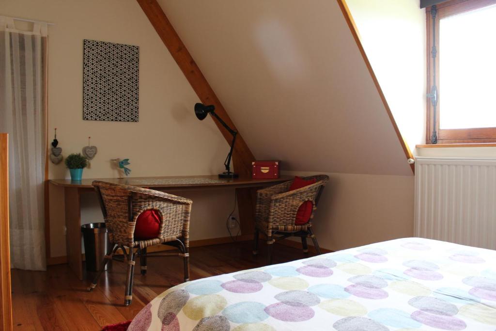 a bedroom with a bed and a desk and chairs at Gîte Pressoir Armand in Saint Gatien des Bois