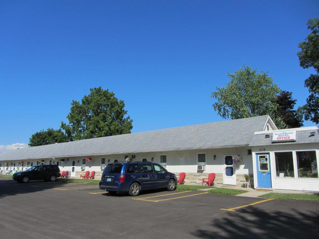 a building with a car parked in a parking lot at The Maplewood Motel in Port Elgin