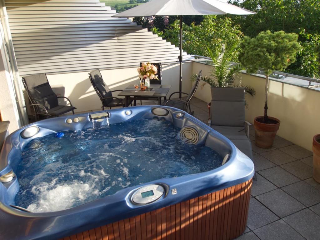 bañera de hidromasaje en un patio con sombrilla en Apartmány Luhačovice, Royal en Luhačovice