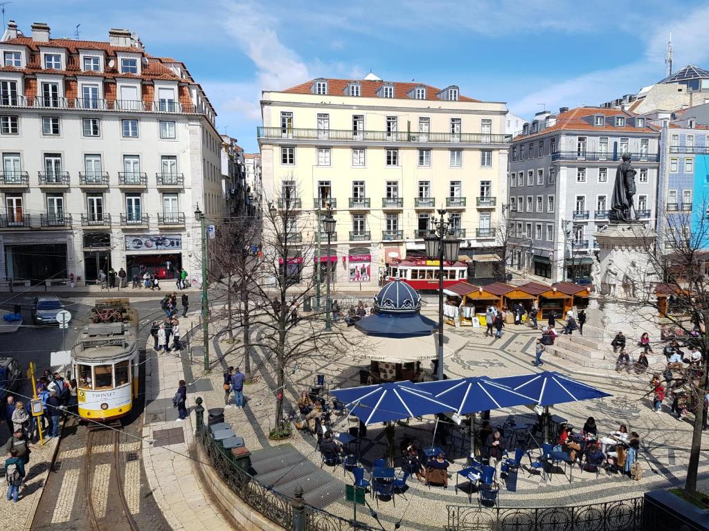 un tram in una città con persone ed edifici di La PERLE de Lisbonne ! a Lisbona