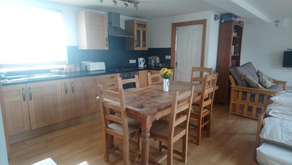 eine Küche mit einem Holztisch und einigen Stühlen in der Unterkunft Rebels Hide -Self check in rooms in Penrith