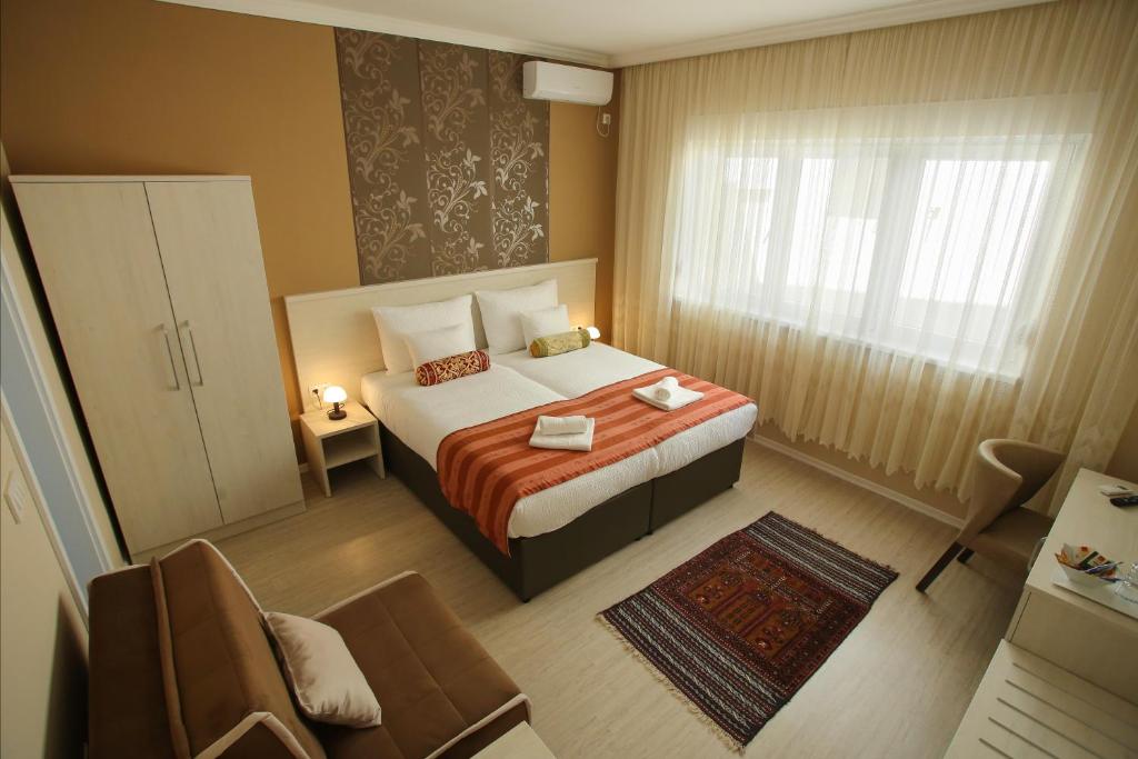 Habitación de hotel con cama y silla en Villa Prestige, en Mostar