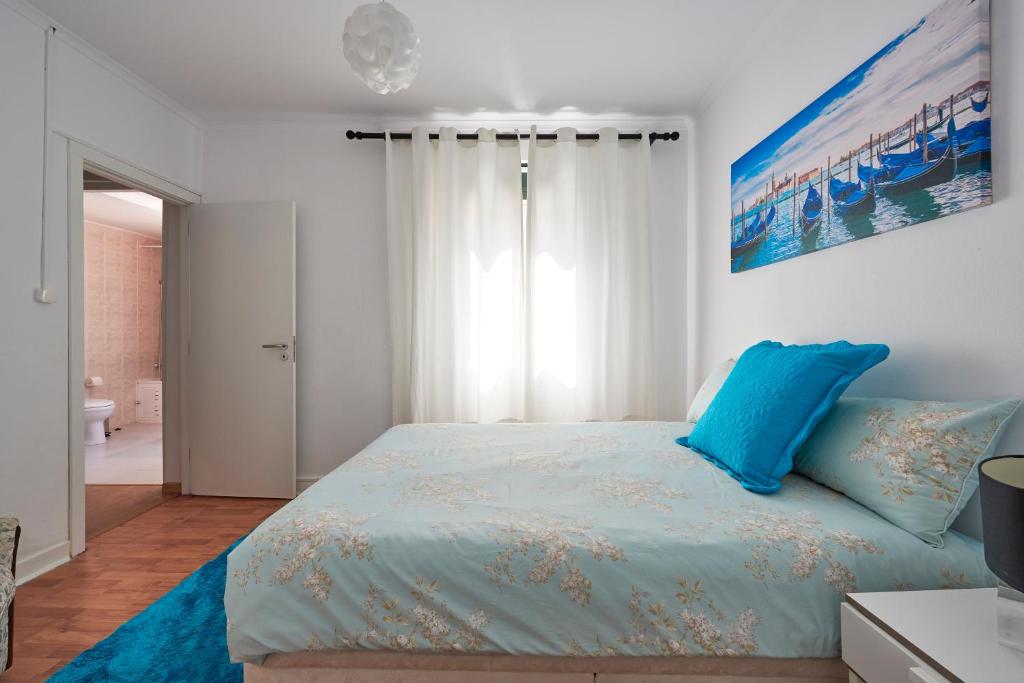 リスボンにあるT3 in Casa da Mariquinhas (3 bedroom flat)のベッドルーム(青い枕の大型ベッド1台付)