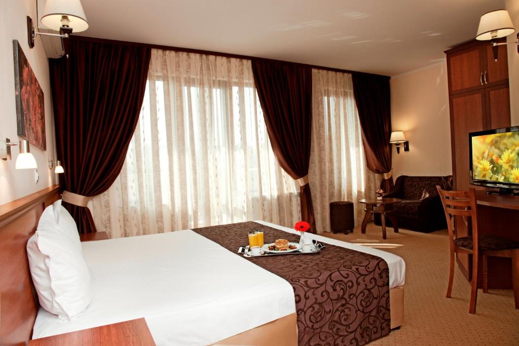 een hotelkamer met een bed, een tafel en een televisie bij Favorit Hotel in Sofia