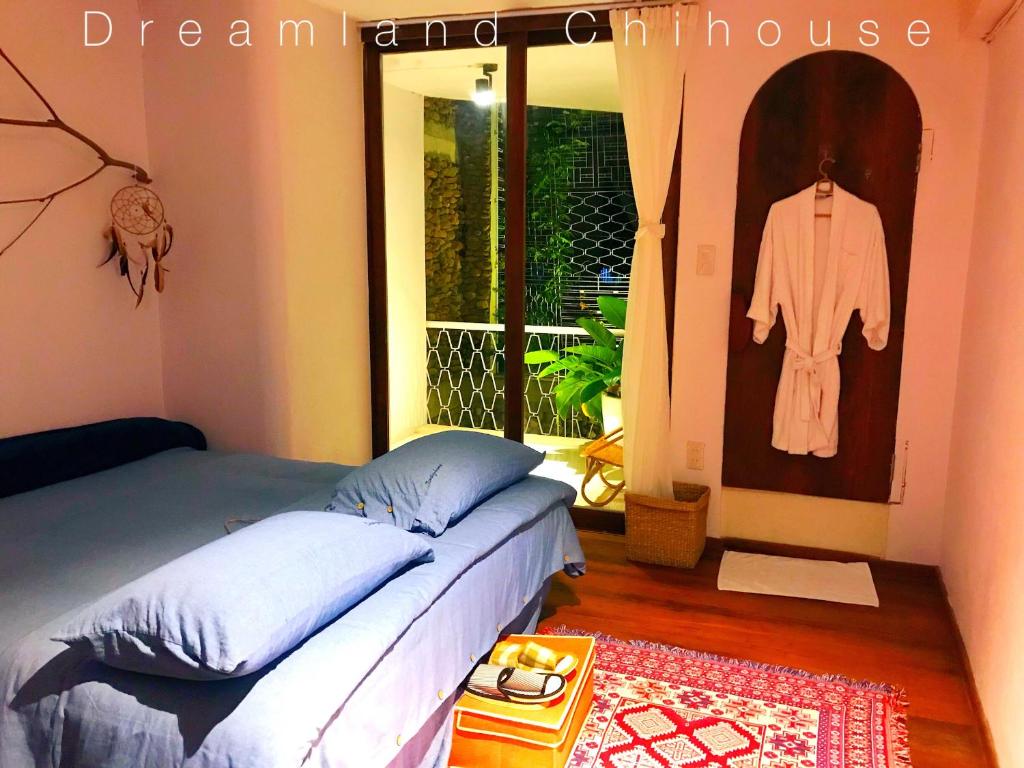 a bedroom with a bed and a dress hanging on the wall at Dreamland - Chihouse in Hai Phong