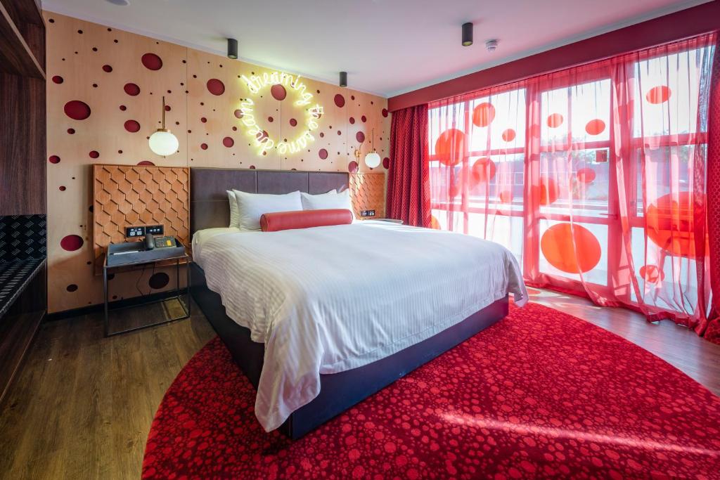 a bedroom with a large bed and a red rug at Naumi Auckland Airport Hotel in Auckland