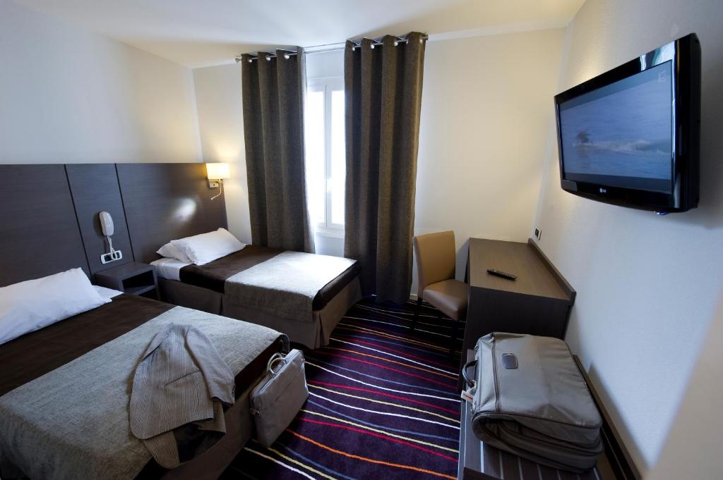 Tempat tidur dalam kamar di The Originals City, H&ocirc;tel Astoria Vatican, Lourdes (Inter-Hotel)