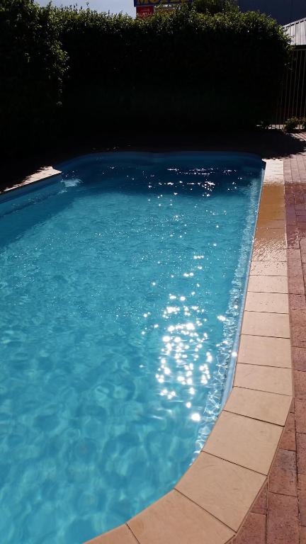una piscina de agua azul en un patio en Yambil Inn, en Griffith
