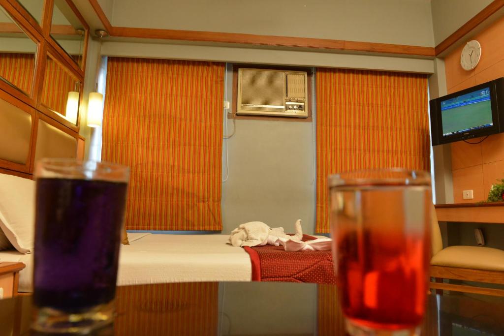 a room with a bed and a table with a drink at Sree Bharani Hotels in Tirunelveli