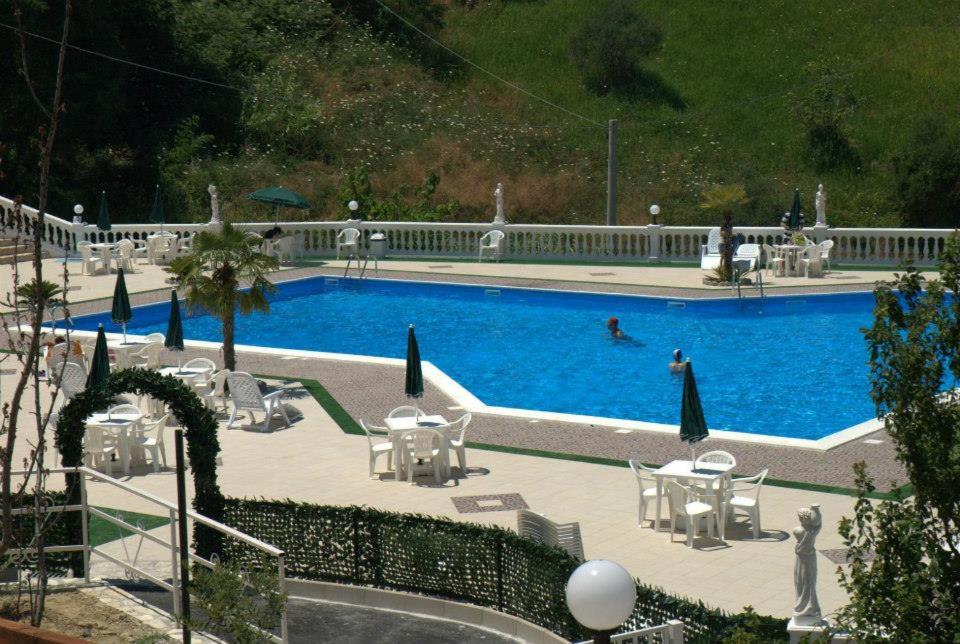 een zwembad met stoelen en een persoon die erin zwemt bij Bed e Breakfast Sanmarco in San Marco Argentano