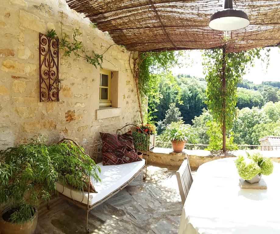 eine Terrasse mit einem Tisch, Stühlen und einem Fenster in der Unterkunft Le Logis d'Hortense in Vic-le-Comte