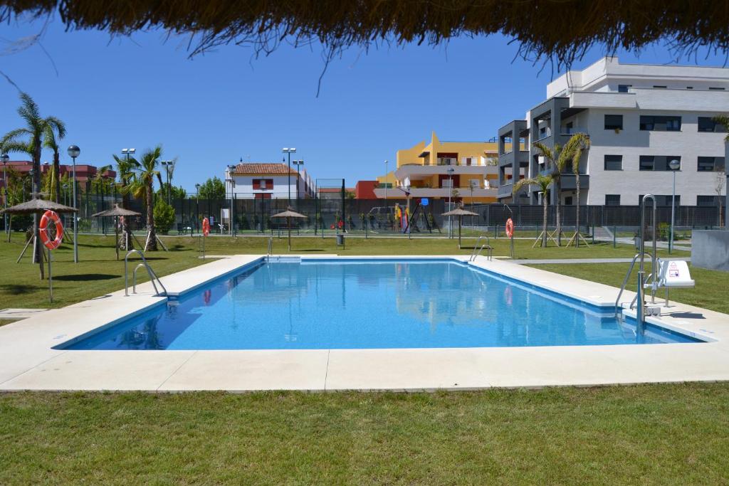 een zwembad in het midden van een park bij Residencial Costa Doñana (Sanlucar de Barrameda) in Sanlúcar de Barrameda