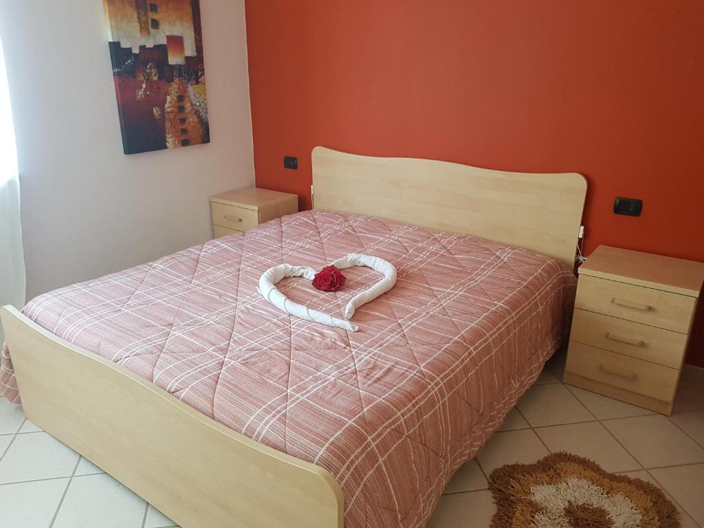 ein Schlafzimmer mit einem Bett mit einem handgefertigten Herz in der Unterkunft A Casetta in Putignano