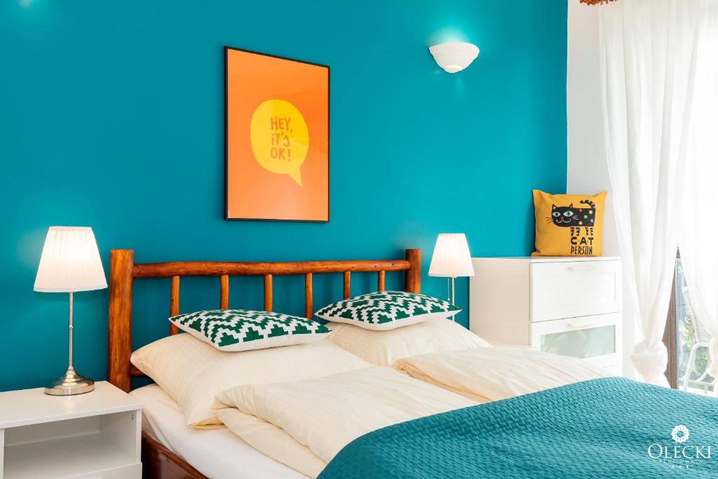 1 dormitorio azul con 2 camas y almohadas en OLECKI Holiday Haus, en Dźwirzyno