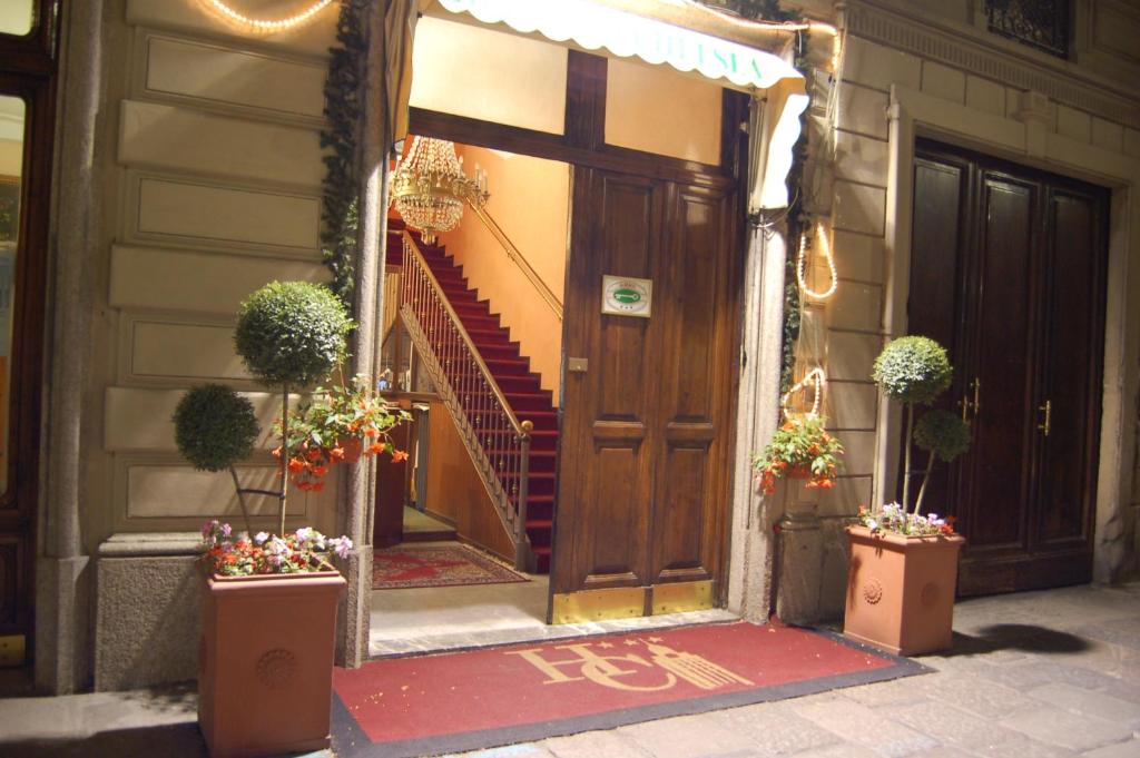 a front door of a house with stairs and potted plants at Hotel Chelsea in Turin