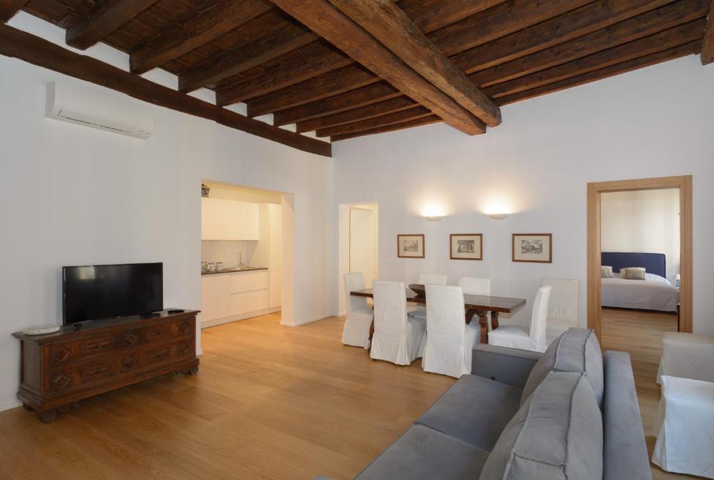 ein Wohnzimmer mit einem Sofa, einem TV und einem Tisch in der Unterkunft Ca' Zacco in Venedig