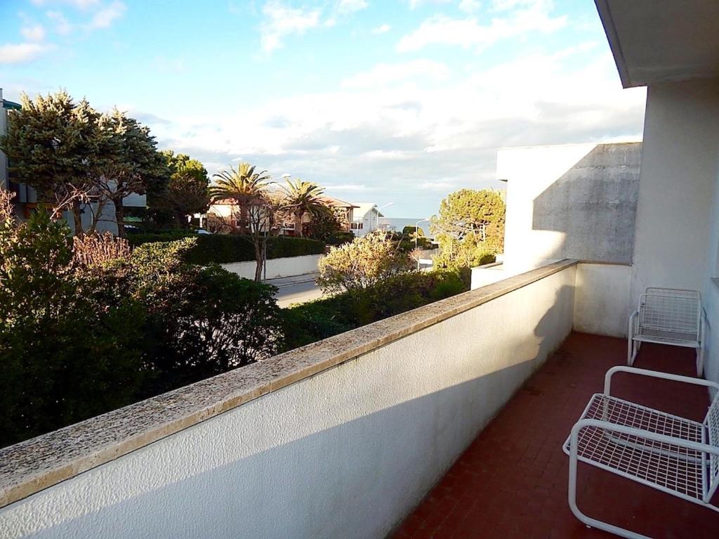 - un balcon avec un mur blanc et 2 chaises dans l'établissement M166 - trilocale con aria condizionata a 50 mt dal mare, à Marcelli