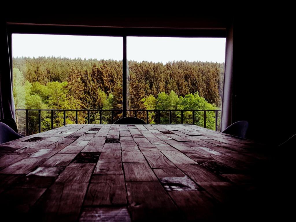 a wooden table in front of a large window at Vintage Racing House in Stavelot