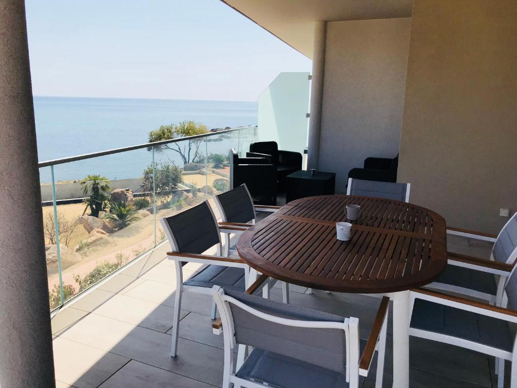 サリ・ソランザラにあるCorsicacasa Appartement Sur La Mer Port De Solenzaraの海を望むバルコニー(テーブル、椅子付)