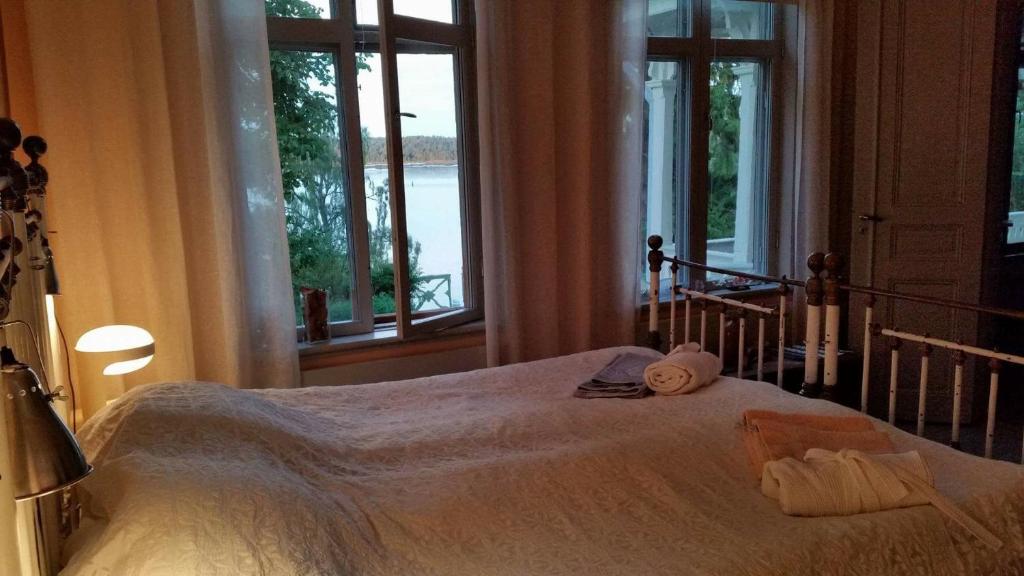 Schlafzimmer mit einem Bett und Blick auf das Wasser in der Unterkunft B&B Direktörsvillan Oaxen in Mörkö