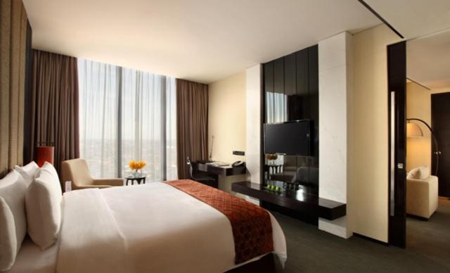 Habitación de hotel con cama grande y escritorio. en PO Hotel Semarang, en Semarang