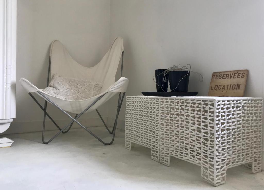 a white chair and a table in a room at "Côté cour, côté jardin" in Bonnes