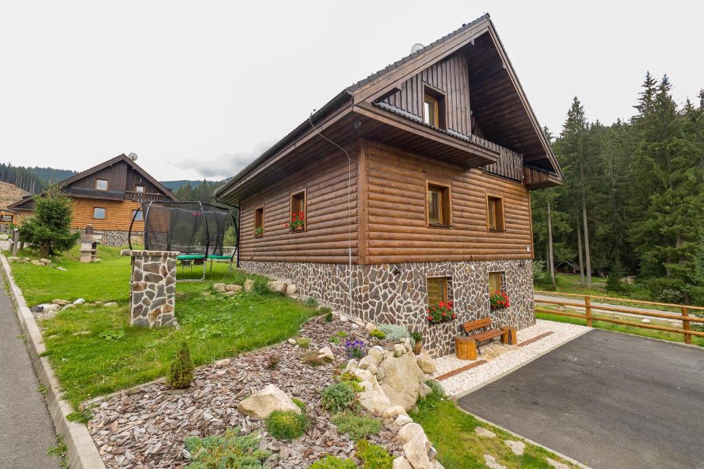 ein großes Holzhaus mit Garten davor in der Unterkunft Apartment House Kongen in Demänovská Dolina