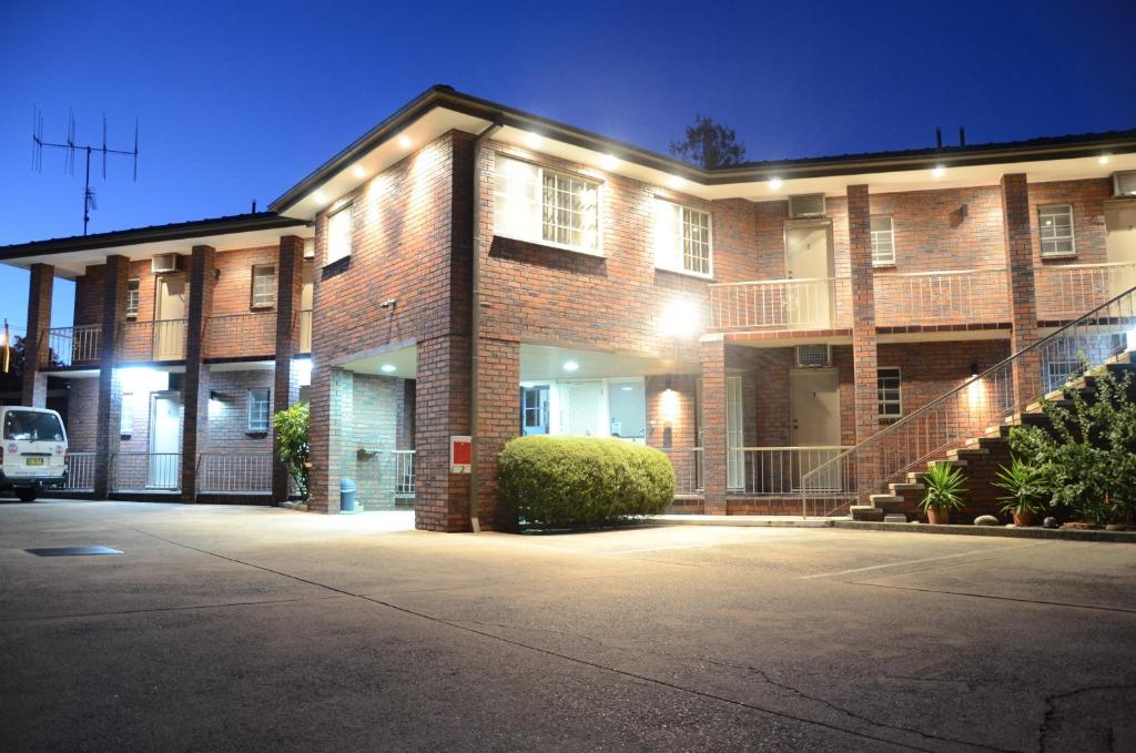 a large brick building with a car parked in front of it at Motel Margeurita in Queanbeyan