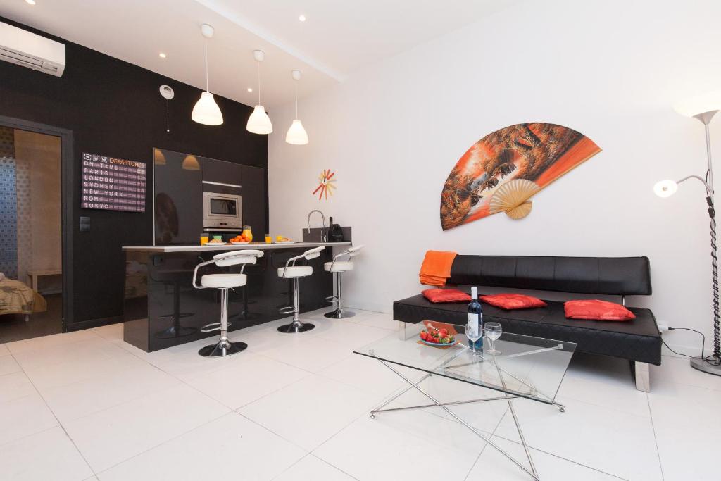 a living room with a black couch and a table at Voyage 2 pièces 3 étoiles calme plein centre à 5mn des plages et du Palais in Cannes