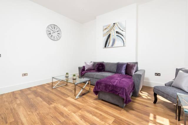 een woonkamer met een bank en een tafel bij Stunningly Luxurious London Apartment (MHB350) in Londen