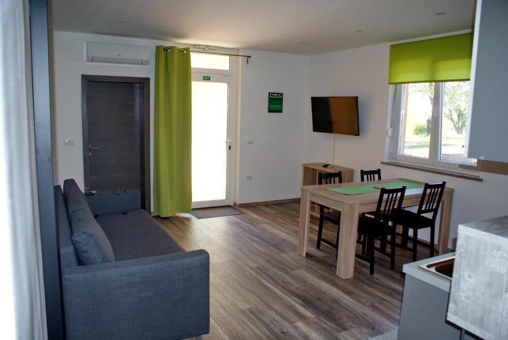 a living room and kitchen with a couch and a table at Apartments Zec in Buje