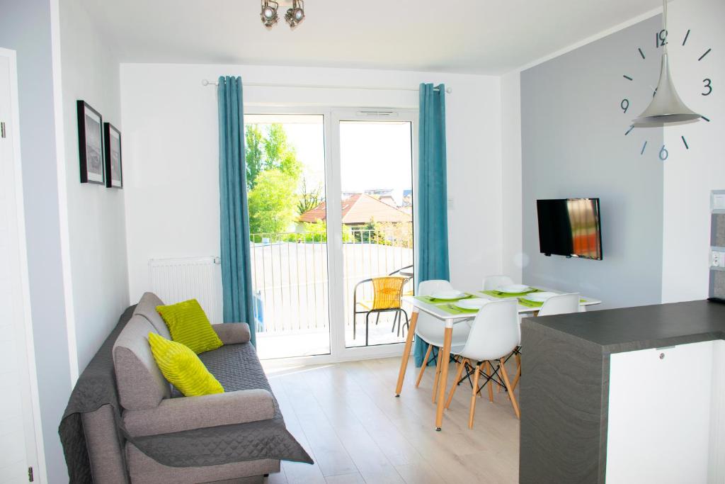 a living room with a couch and a table at Grey & White Pogodne in Kołobrzeg