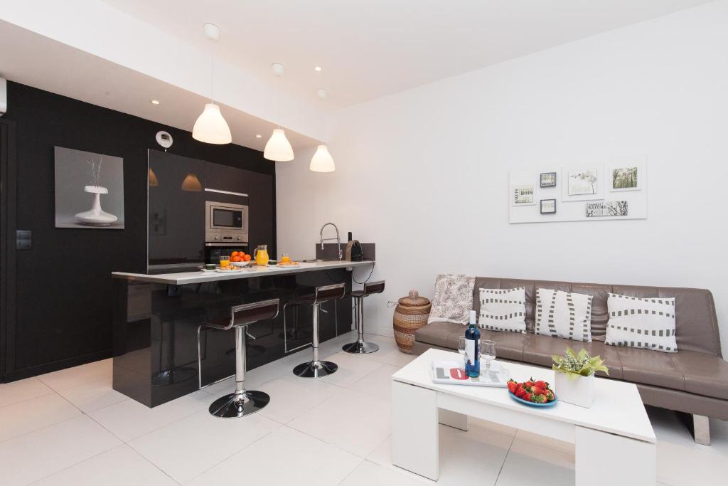 une cuisine et un salon avec un canapé et une table dans l'établissement Nature 2 pièces 3 étoiles calme plein centre cannes 5 mn des plages et Palais, à Cannes